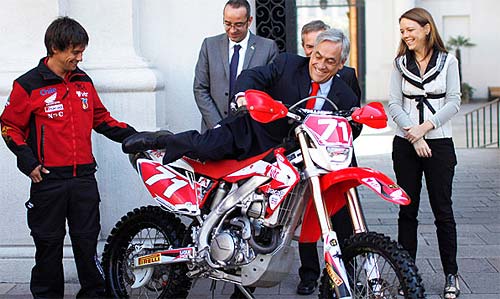 Sebastián Piñera se sube a una moto en la confirmación del Dakar 2011.