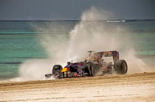 Alguersuari al mando de un Fórmula 1 de Red Bull en la playa de República Dominicana.