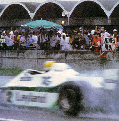 Pasa Reutemann sin mirar el cartel que le muestran en boxes.