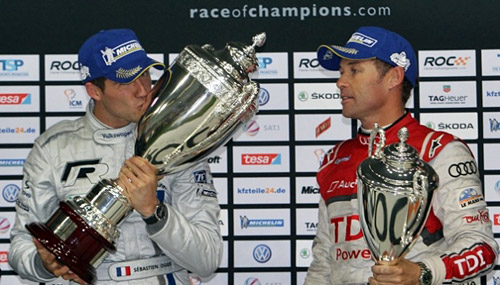 Sébastien Ogier besa el trofeo de la Copa de Campeones 2011 ante la mirada de Tom Kristensen.