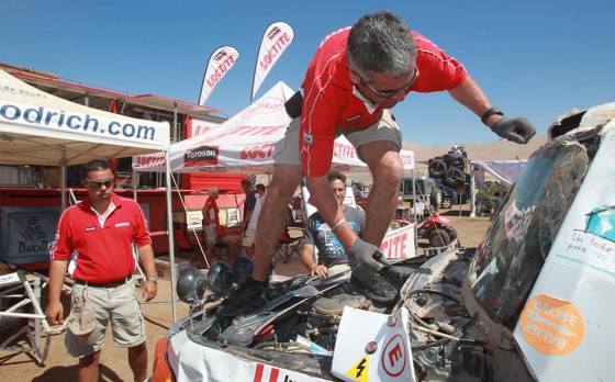 Los Loctite Charlies reparando un parabrisas en el Dakar 2012.