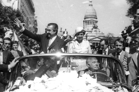 Alfonsín y su esposa Lorenza saludan en el Cadillac presidencial.